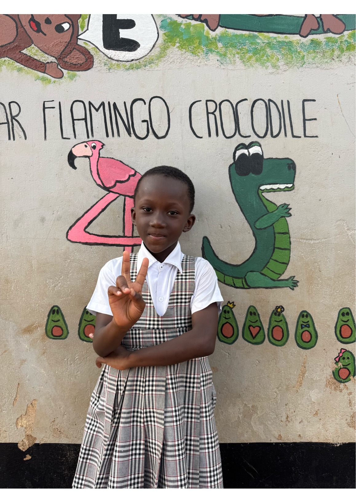 Bambina davanti al muro dipinto della scuola